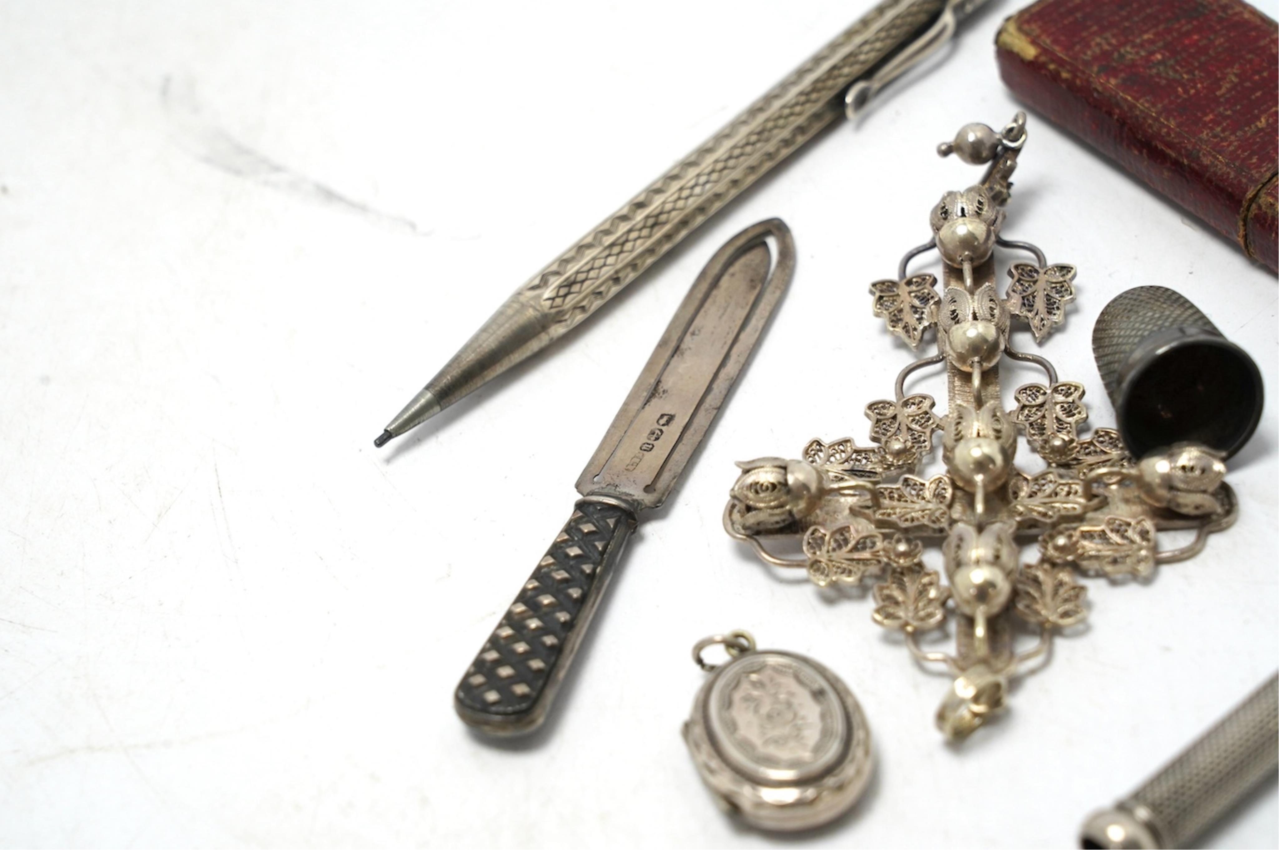 Small silver including a Victorian silver and mother of pearl fruit knife, a crucifix, a book mark, pencils, a thimble, etc. Condition - fair